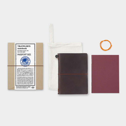 TRAVELER’S notebook Passport Size in Brown – leather cover with elastic closure, shown with accessories including cotton bag, refill, and spare band.