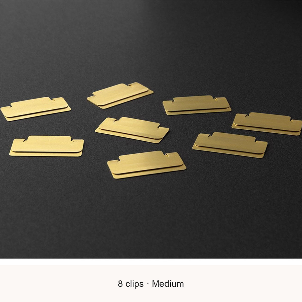 Eight Midori Chiratto medium brass index clips, with English feature captions