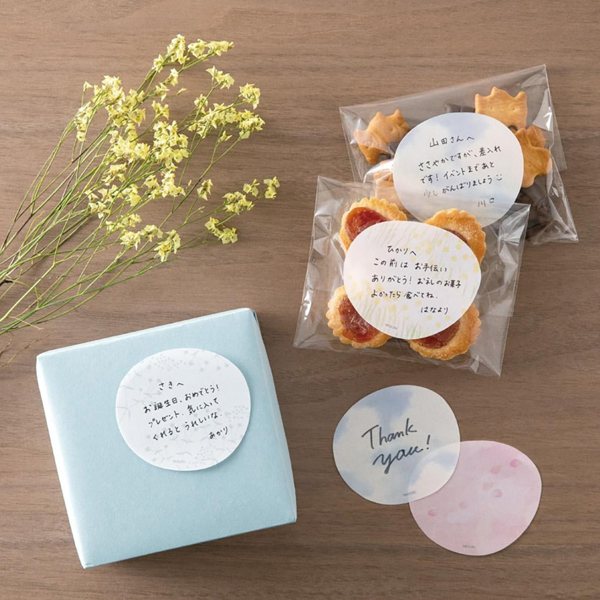 A hand peeling a translucent sticky note from a circular sky-themed pad with cloud design