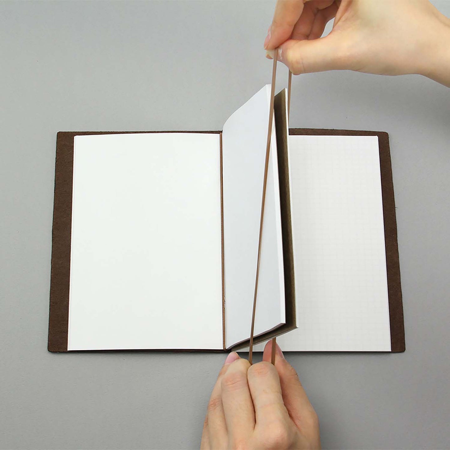 Set of TRAVELER’S notebook Passport Size Connecting Rubber Bands in black and brown – used to join multiple refills.