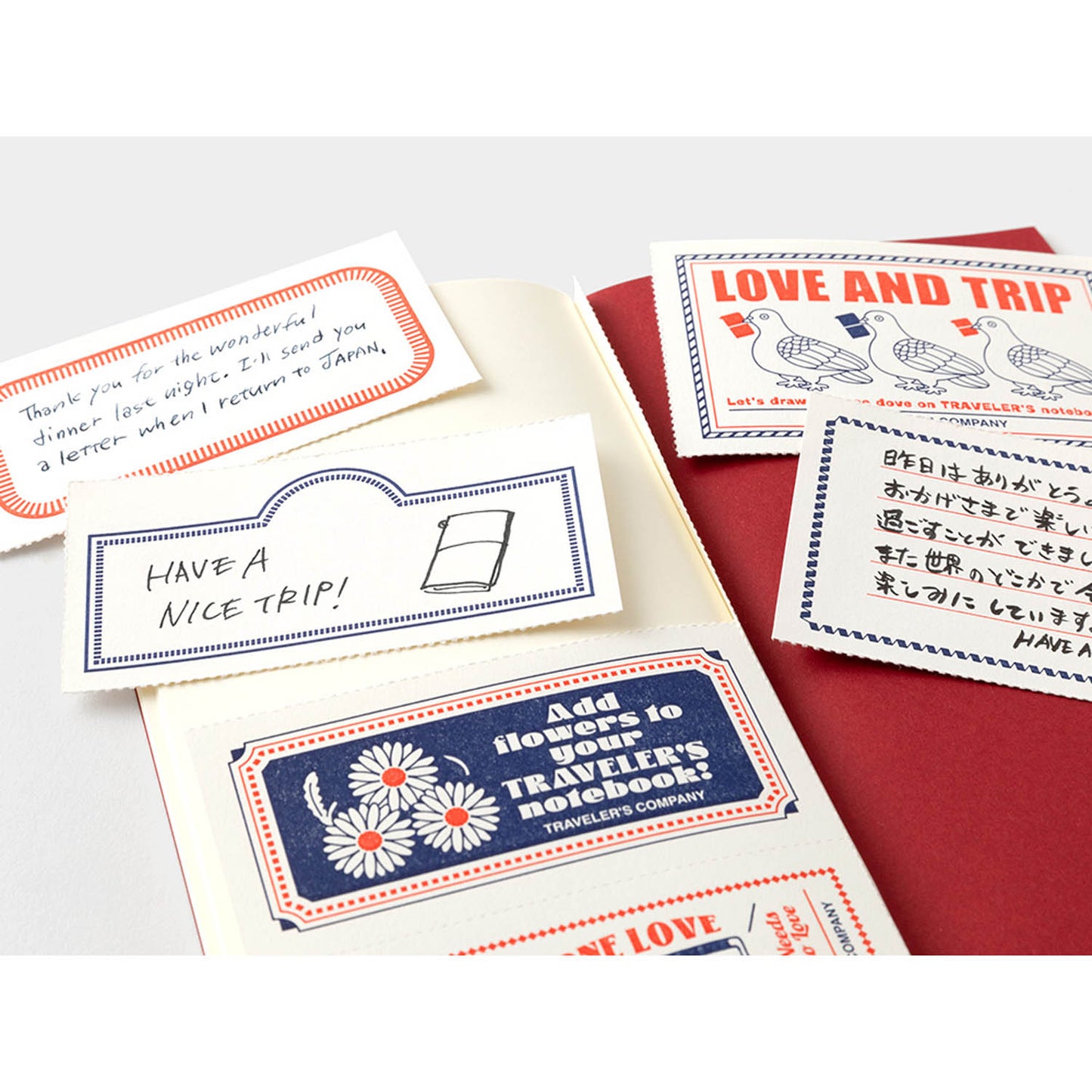 TRAVELER’S notebook Love & Trip refill with red cover and gold foil dove design. Includes MD Cream Paper and perforated message cards.