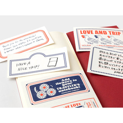 TRAVELER’S notebook Love & Trip refill with red cover and gold foil dove design. Includes MD Cream Paper and perforated message cards.