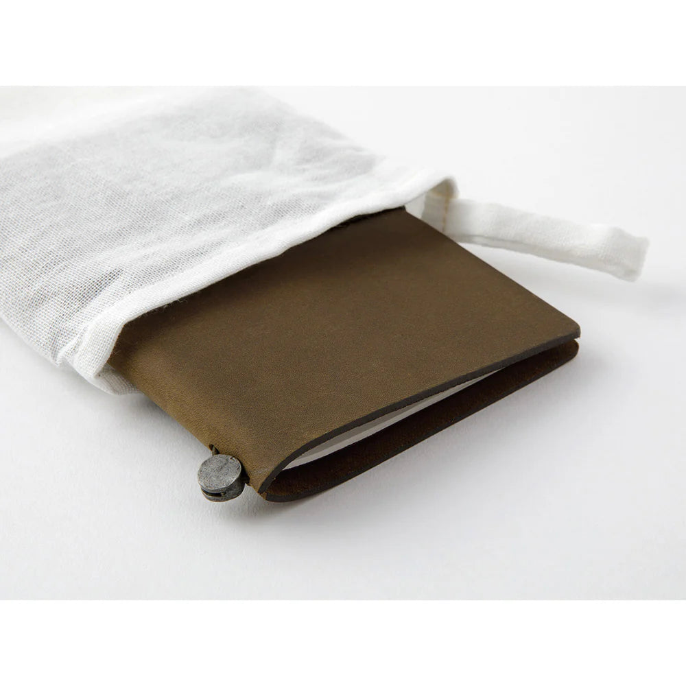 TRAVELER’S notebook in Olive – a dark brownish-green leather cover with earthy, rugged tones that deepen and develop a rich patina over time. Includes cotton bag, blank refill, and spare band.
