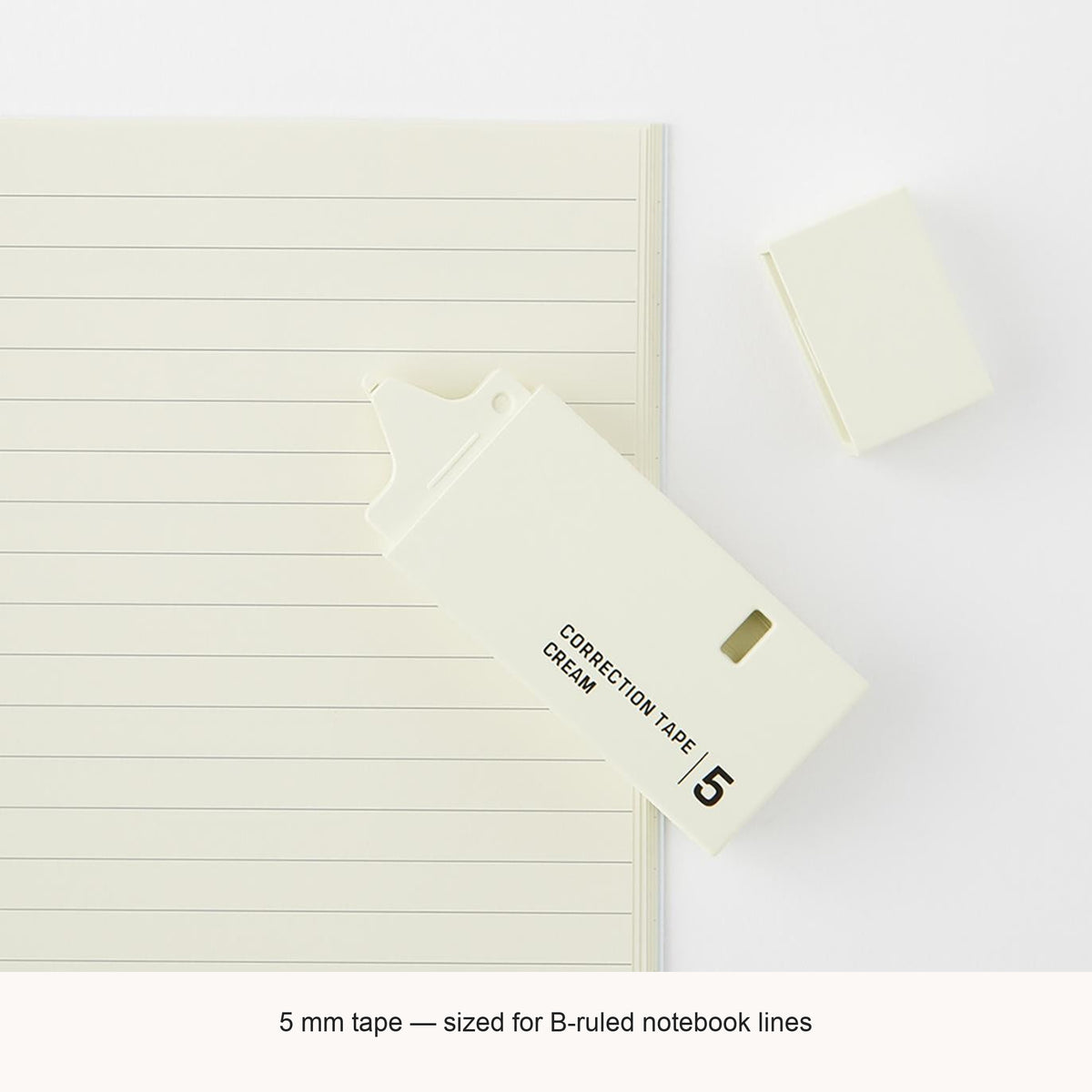 Midori cream correction tape beside a lined notebook, with an English caption explaining the 5mm tape width