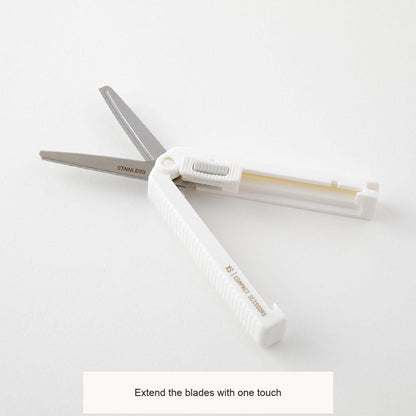 Midori XS white scissors opened on a desk, with English feature captions