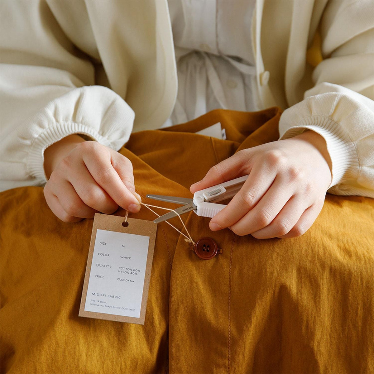 Midori XS scissors being used beside a hanging notepad