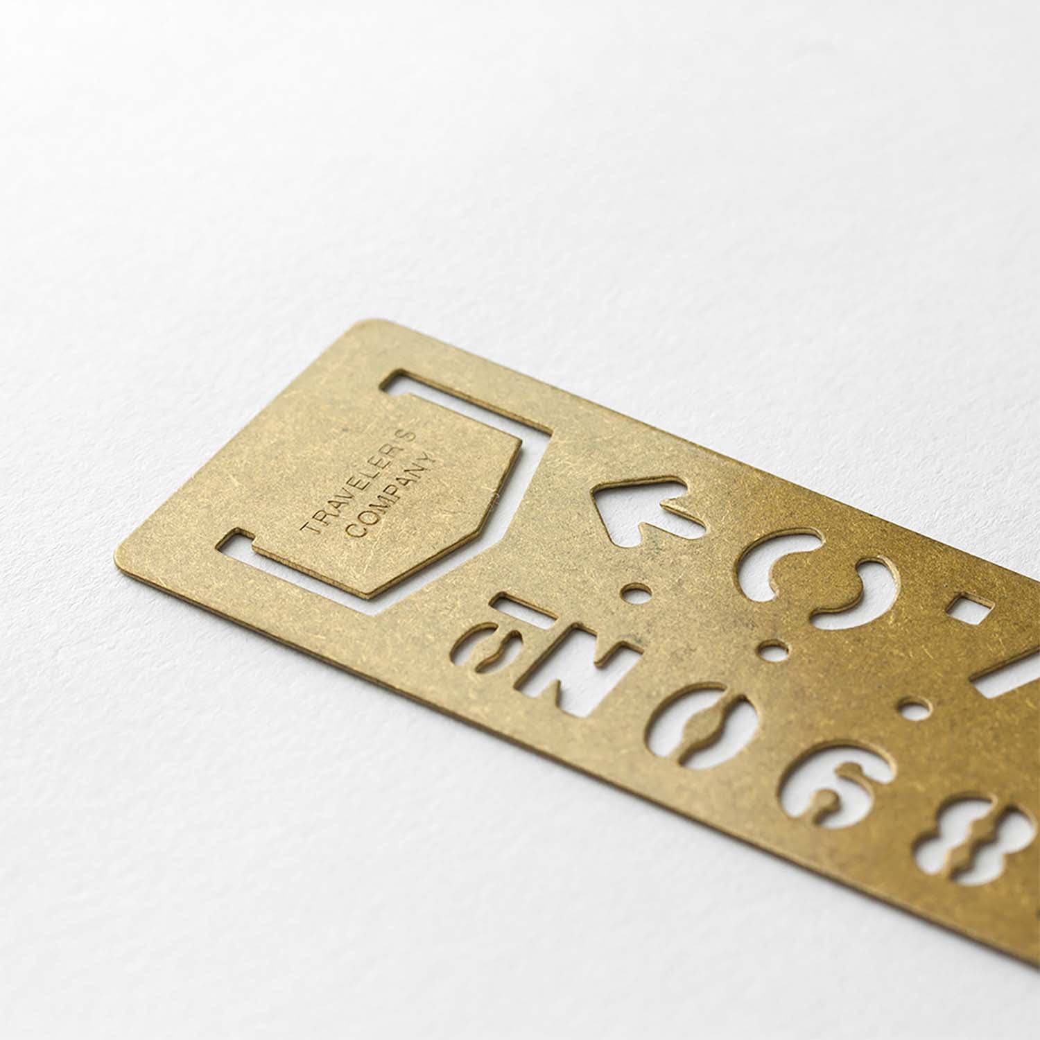 Traveler’s Company brass stencil bookmark with numbers and travel-themed icons