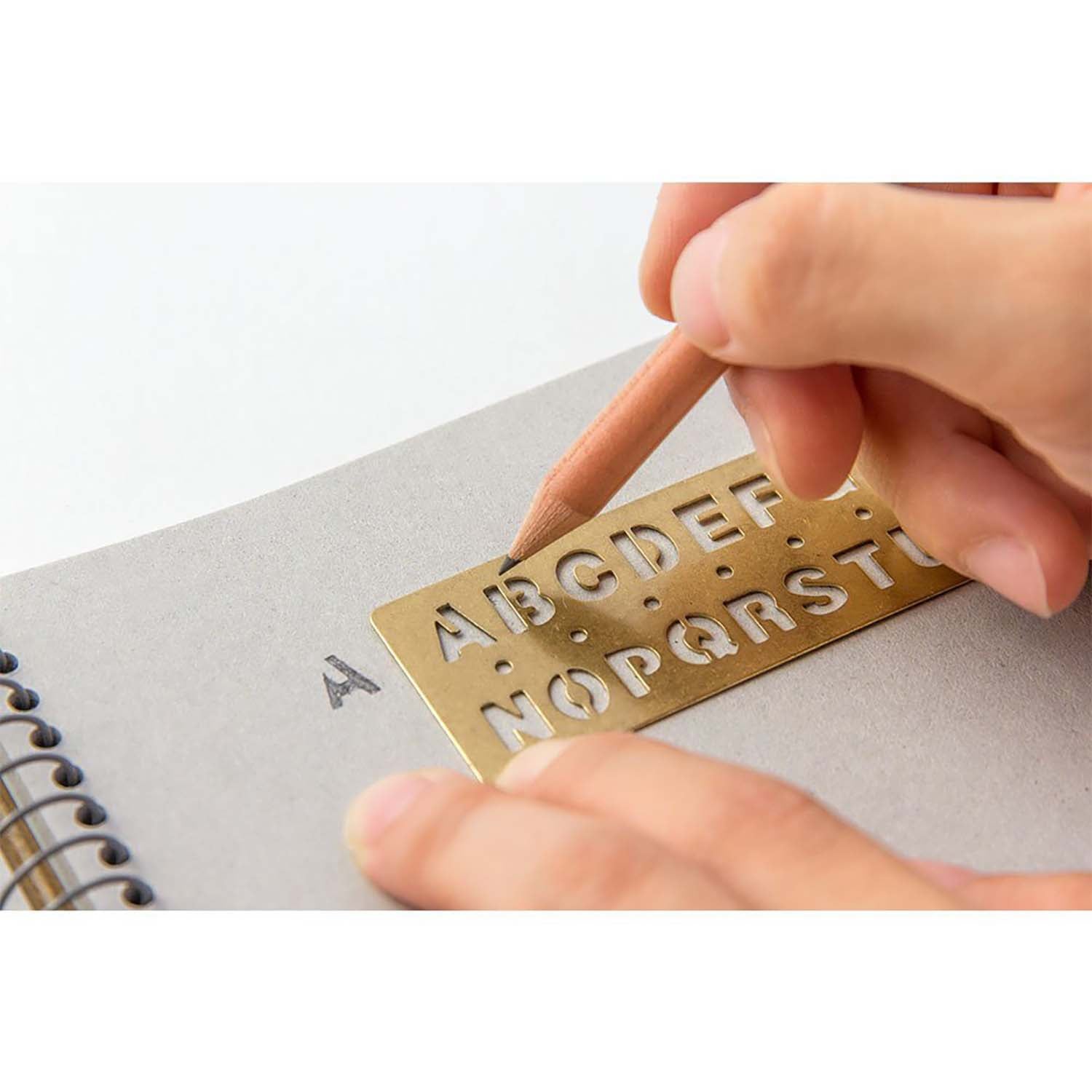 Brass stencil bookmark with uppercase A–Z letters by TRAVELER'S Company