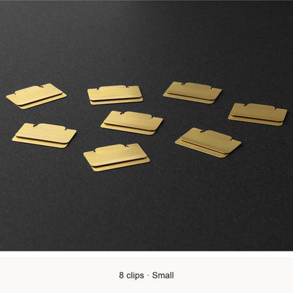 Eight Midori Chiratto small brass index clips, with English feature captions