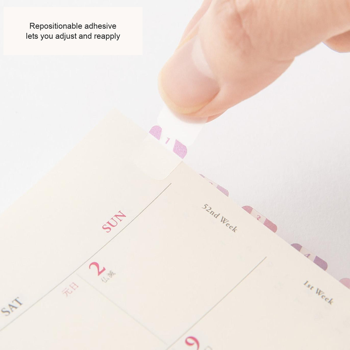 Hand placing a Midori Chiratto number tab on a planner page, with English feature captions