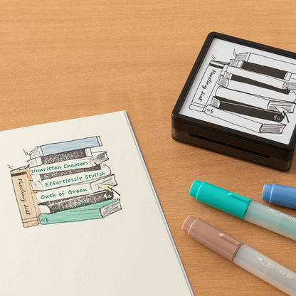 Midori pre-inked reading list stamp with stacked books illustration, black ink design, paintable journal stamp for book tracking