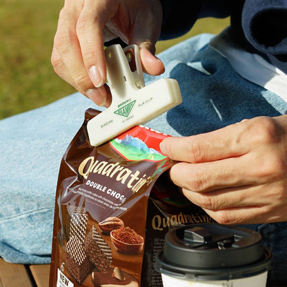 Penco glow-in-the-dark Clampy clip sealing a snack bag outdoors