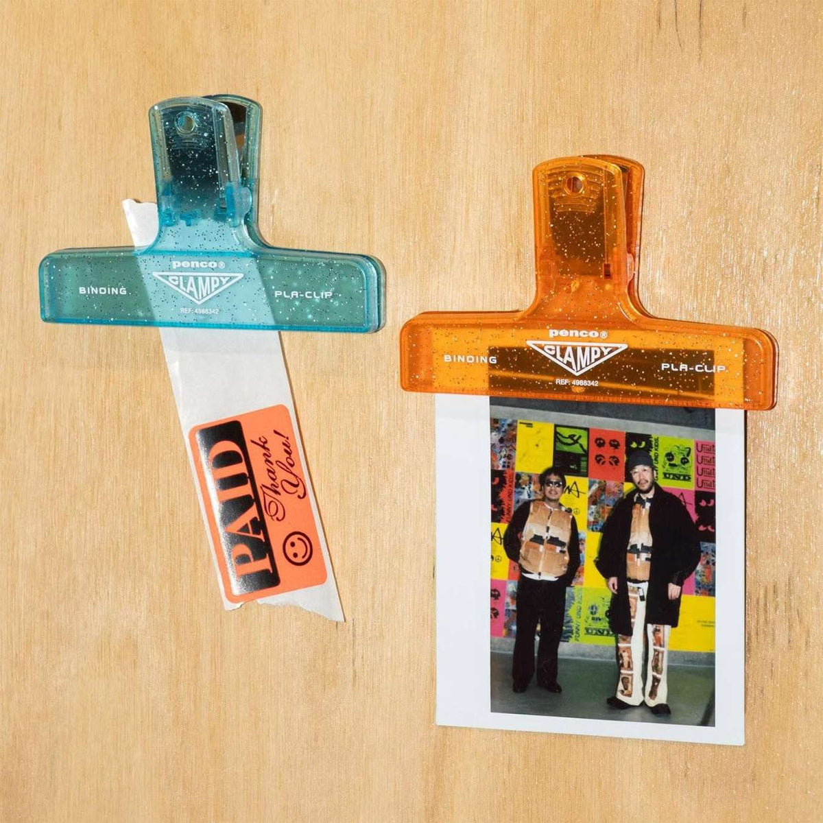 Blue and orange glitter Penco Clampy clips holding tickets and pictures