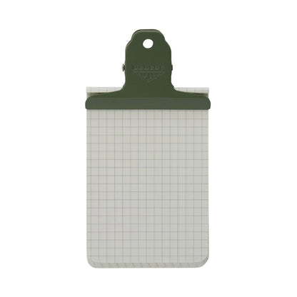 Small green Penco steel Clampy clip holding a grid notepad